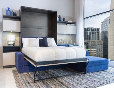 Lit escamotable blanc ouvert avec divan dans un loft