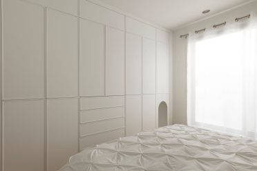 Mobilier sur mesure Limuro avec niche arrondie intégrée pour chat, dans une chambre minimaliste aux lignes épurées. Un aménagement fonctionnel et élégant adapté à la vie quotidienne.