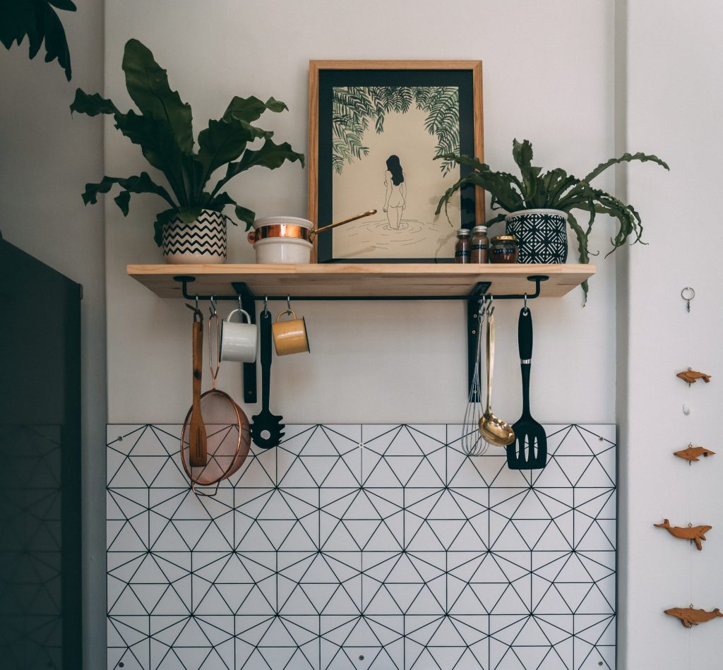 Astuce de rangement maison : casseroles et outils de cuisine suspendus pour un espace optimisé.
