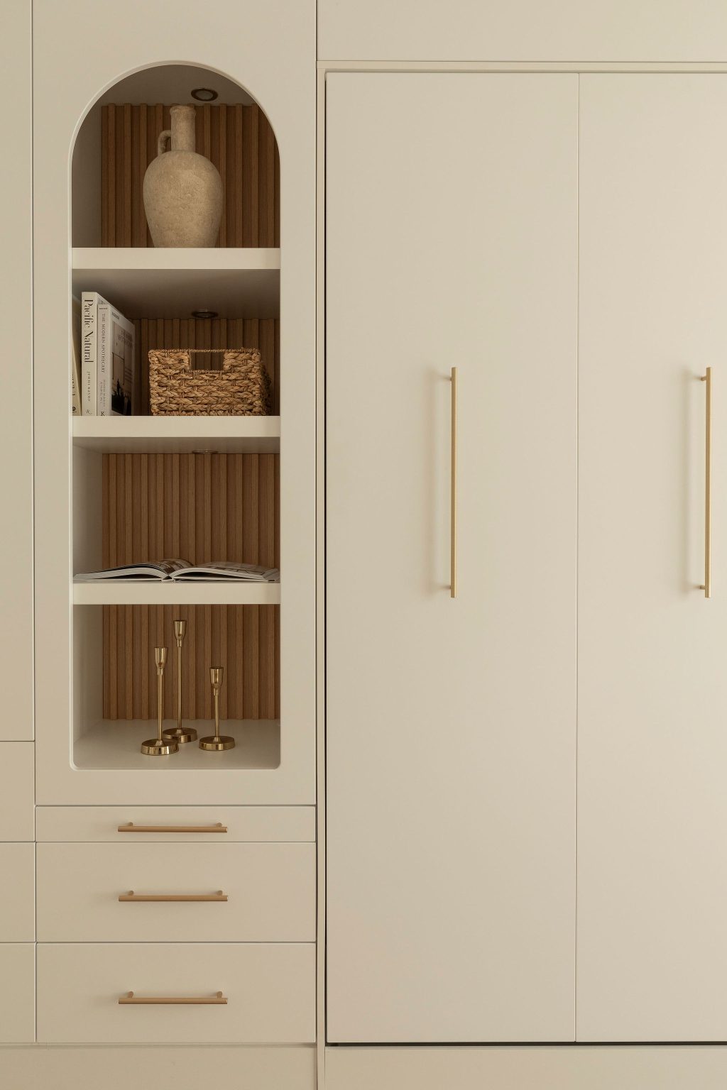 round-image static-image Détail du mobilier sur mesure Limuro : niche décorative au dos en lambris de bois, intégrant des étagères ouvertes, une céramique artisanale et des poignées dorées raffinées, dans une composition harmonieuse et contemporaine.